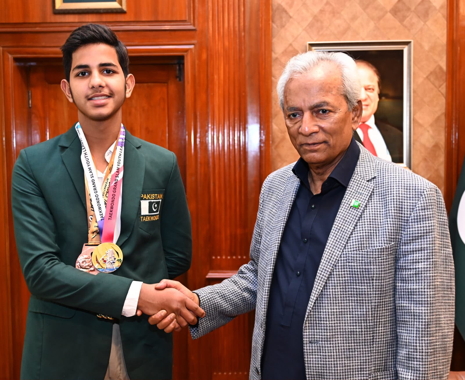 Arham Khan with senior official at Governor House, wearing Pakistan Taekwondo blazer with Grand Slam medals